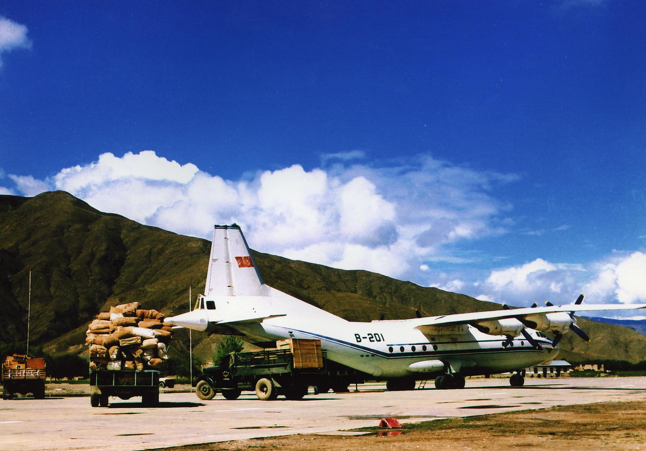 MB000815-民航工业航空公司的安-12货机在西藏贡嘎机场装运援藏货物照片.jpg